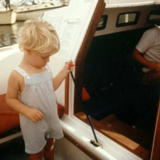 An unknown captain demonstrating the pull required to operate the centerboard on a (now) vintage Rhodes. Note the sale price on this boat show boat!  (Photo courtesy of General Boats)